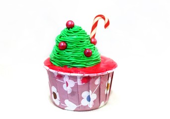 Cupcakes with Christmas tree shape and candy stick over white background