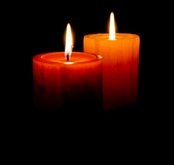 Red an orange candle before the dark with black background