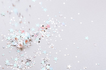 Shot of flying holographic stars in the air on silver background. Festive concept. Selective focus.