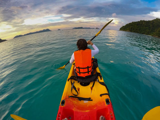 tourist sailing sea kayak in beautiful blue water of tropical island