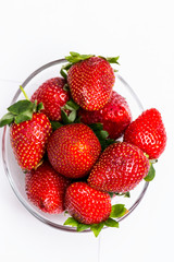 The glass bowl filled with red strawberries