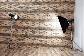 Professional lighting equipment near wall in photo studio. Space for text