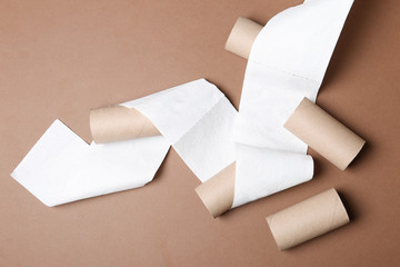 Flat lay composition with toilet paper and empty rolls on color background