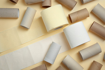 Full and empty toilet paper rolls on color background, top view