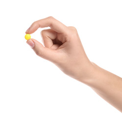 Woman holding color pill on white background, closeup