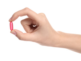 Woman holding color pill on white background, closeup