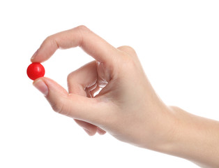 Woman holding color pill on white background, closeup
