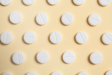 Flat lay composition with white pills on color background