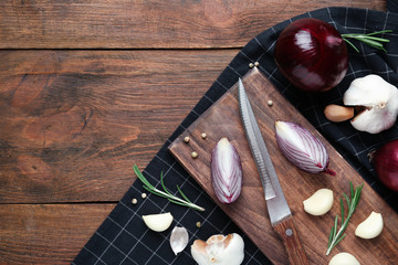 Flat lay composition with garlic, onions and space for text on wooden background