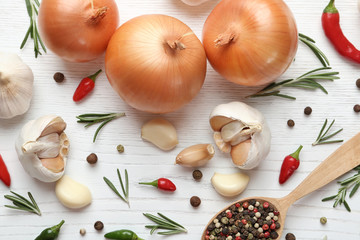 Composition with garlic, peppers and onions on white wooden background, flat lay
