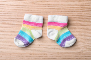 Obraz na płótnie Canvas Pair of cute child socks on wooden background, top view