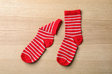 Pair of cute child socks on wooden background, top view