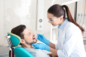 Obraz na płótnie Canvas Professional dentist working with patient in modern clinic