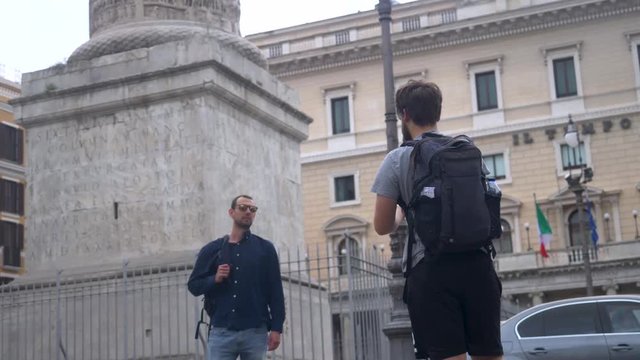 Tourists Taking Photos On Smartphone In Front Of Landmark