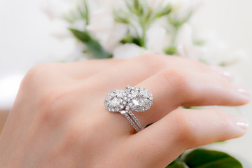 Young lady with a diamond ring in her hand. Lovely background.