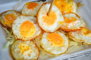 fried egg on rice in box / Quail fried egg with Vegetable in street food