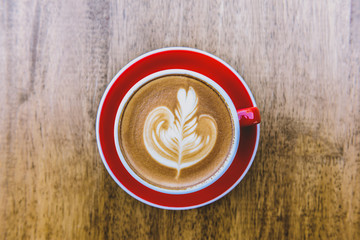 red cup of hot latte coffee with latte art