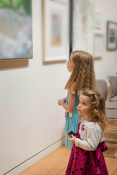 Two little girls are looking at the pictures in the Art Gallery 