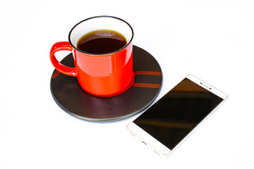 Red coffee mug A mobile phone is placed next to it.  isolation On a white background