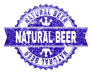 NATURAL BEER rosette stamp seal watermark with grunge texture. Designed with round rosette, ribbon and small crowns. Blue vector rubber watermark of NATURAL BEER title with unclean texture.