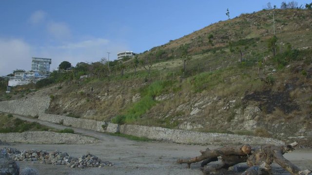 Wide close-up panning shot of villagers encroaching on coastline forests, and systematic deforestation, Moresby, Papua