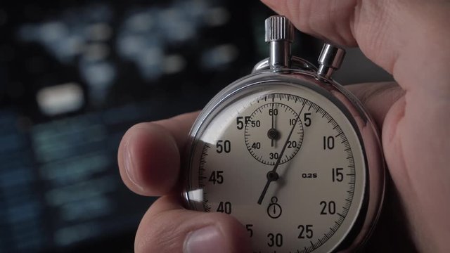 Close-up of one person starting up a stopwatch at hacker programmer screen background. Deadline concept. 4K, 10 BIT, 4:2:2