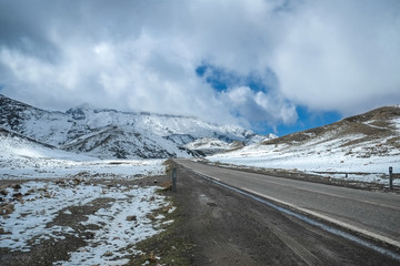 A road surrounded by snow capped mountains in the High Atlas range. Morocco.