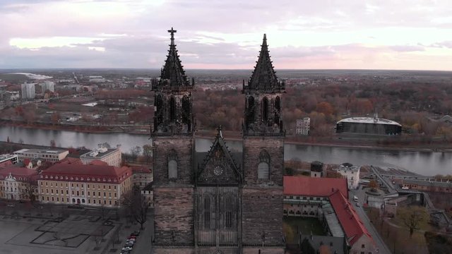 Fly through the cathedral at autumn in magdeburg with a river.