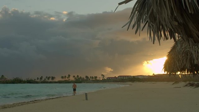 Young man running on beach side against light in Cayo Coco Cuba