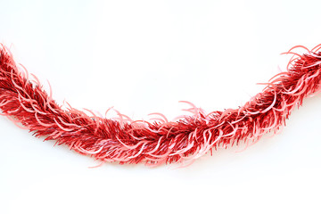 Red colors bunch fur or Christmas tree tinsel garland on white background. Christmas and New year celebration.