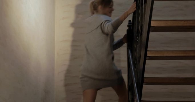 Flirty woman wants the viewer to follow her upstairs