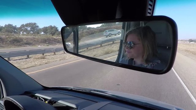 Woman driving a van. Mirror shot.