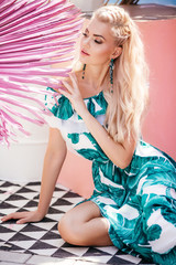 Portrait of beautiful young blonde is in a bright summer clothing