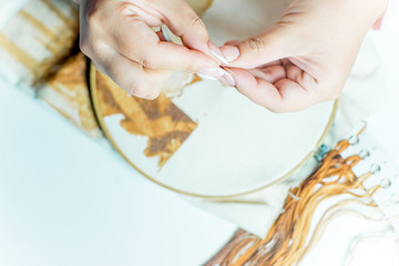 hands are sewing with thread and needle