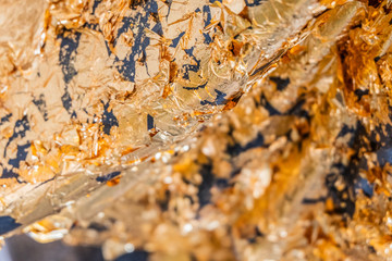 Gold leaf or Gold foil texture of buddhism on The Buddha statue in temple at thailand