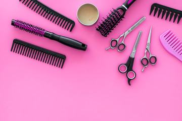 female hairdresser desk with accessories and combs on pink background top view mock up