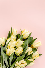 Pastel and yellow tulip flowers bouquet on pink background. Flat lay, top view. Valentine's background. Minimal floral concept.
