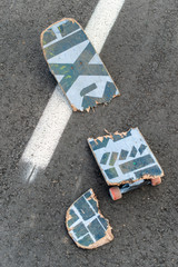 Broken skateboard on dark asphalt street