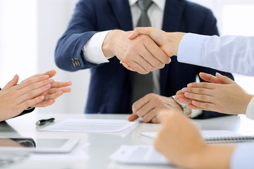 Group of business people or lawyers shaking hands finishing up a meeting , close-up. Success at negotiation and handshake concepts