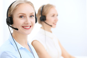 Bright and sunny call center. Group of blonde women in headset at work. Office and business concept