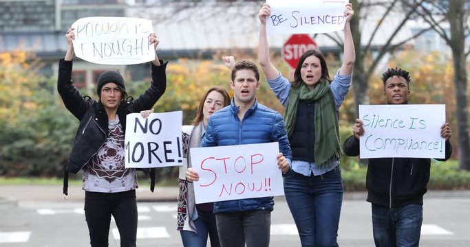Group of protesters marching on the street with signs
