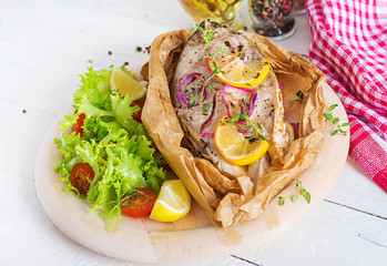 White fish steak (carp) baked in parchment paper with vegetables. Fish dish.