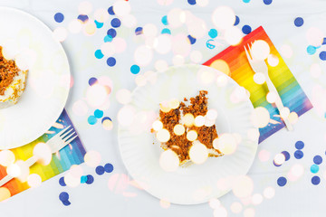 Flat lay with birthday cake pieces on white paper plates. Birthday party celebration concept
