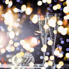 Two glasses of champagne with Christmas toys. Festive lights bokeh background