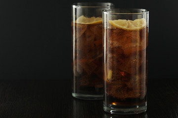 Glasses with cuba libre cocktail or cola with ice or cold tea with lemon