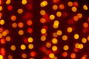 Bokeh abstract texture. Beautiful christmas background in orange colors. Defocused image