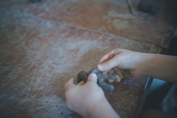 Close up child's hand making a scupture from clay work activity