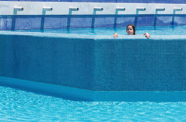 Happy little girl swimming in a pool