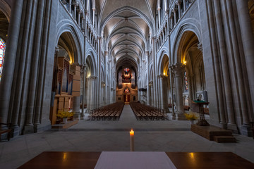 Fototapeta na wymiar Interior of catholic cathedral, candle at foreground