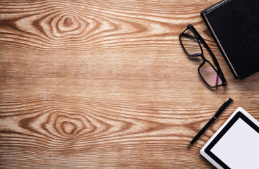 Book, tablet, glasses and pen on wooden table. Ebook concept